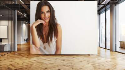 portrait of woman sitting outdoors against white wall Wall mural