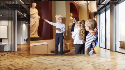 Pupils And Teacher On School Field Trip To Museum With Guide Wall mural