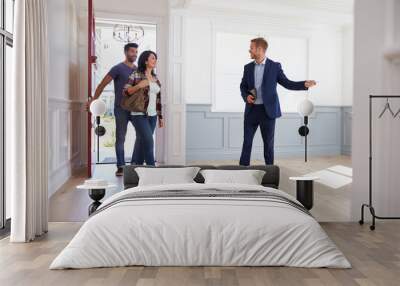 Realtor Showing Hispanic Couple Around New Home Wall mural