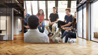 Rear View Of Male Tutor Leading Discussion Group Amongst High School Pupils Wall mural