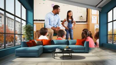 Schoolgirl at front of elementary class with teacher Wall mural