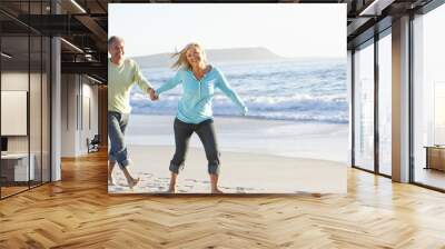 Senior Couple Running Along Beach Wall mural