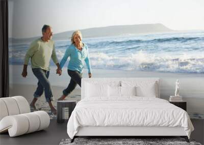 Senior Couple Walking Along Beach Wall mural