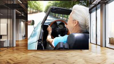 Senior woman in sports car Wall mural