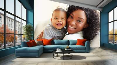 smiling mother playing with baby son at home Wall mural