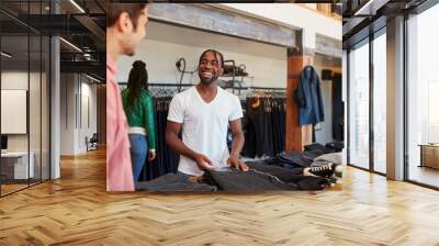 Smiling Sales Assistant Helping Male Customer To Buy Clothes In Fashion Store Wall mural