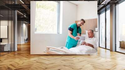 Surgeon With Digital Tablet Visiting Senior Male Patient In Hospital Bed In Geriatric Unit Wall mural