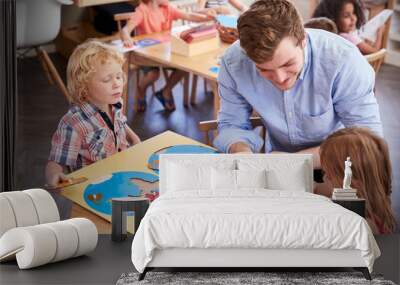 Teacher And Pupils Using Wooden Shapes In Montessori School Wall mural