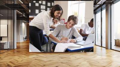 Teacher Helping Male Pupil Using Computer In Classroom Wall mural