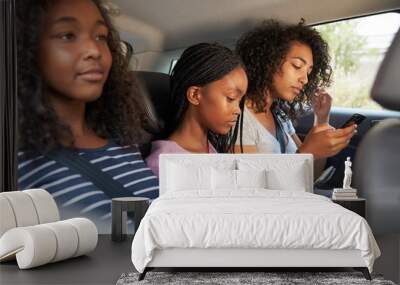 Teenage Children Using Digital Devices On Family Road Trip Wall mural