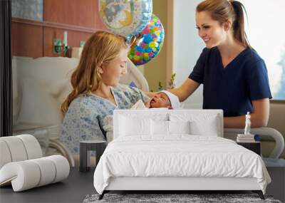 Teenage Girl With Nurse Holding Newborn Baby In Hospital Wall mural