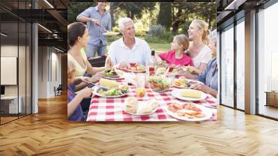 Three Generation Family Enjoying Barbeque In Garden Together Wall mural