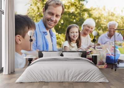 Three generation family having lunch in the garden Wall mural