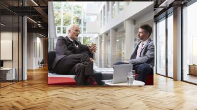 two businessmen meeting in lobby area of modern office Wall mural