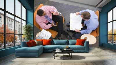 Two businessmen sitting with coffee laptop and folder Wall mural