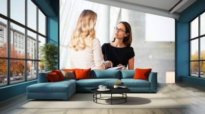 Two Businesswomen Having Informal Meeting In Modern Office Wall mural