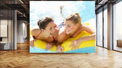 Two women friends having fun together in pool Wall mural