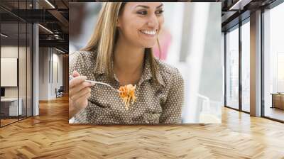 Woman eating pasta at cafe Wall mural