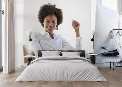 Young black woman in an office smiling to camera, close up Wall mural