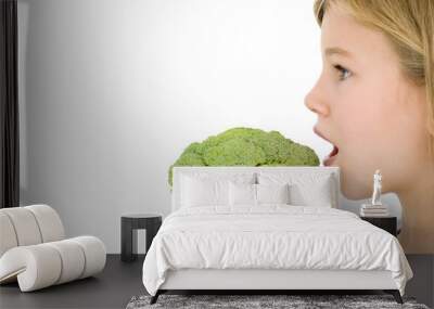 Young girl eating broccoli Wall mural