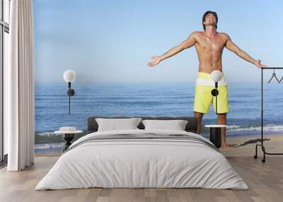 Young Man Standing On Summer Beach Wall mural