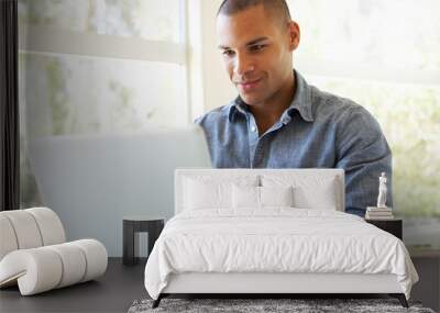 Young Man Using Laptop At Home Wall mural