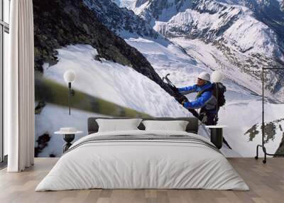 Young men mountain climbing on snowy peak Wall mural