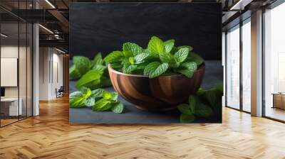 An image of a wooden bowl filled with fresh vibrant green mint leaves Wall mural