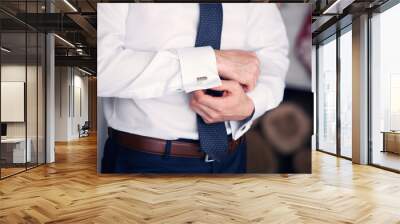 the man clasps cuff links on a shirt Wall mural