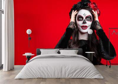 Girl with creative sugar skull makeup with a wreath of flowers on head, wide isolated on red background. Holiday concept Dia De Los Muertos  on poster for Halloween party or La Calavera Catrina. Wall mural