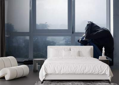 Lonely, depressed, upset young woman in hood is sitting on windowsill and crying in abandoned building. Homeless teenage girl ran away from home because of problems. Alcohol abuse, addiction concept. Wall mural