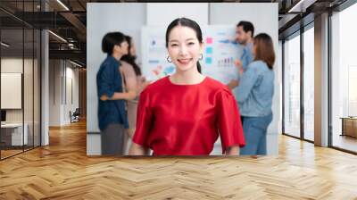 Confidence team leader. Young women asian owner startup business looking camera with smile while his colleagues working in the background Wall mural