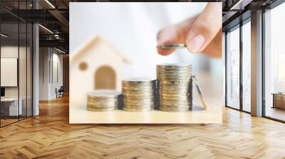 Property investment and house mortgage financial concept, Hand putting money coin stack with wooden house Wall mural