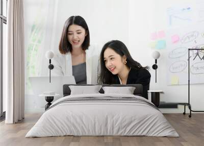 Two beautiful young asian business woman people have fun and talking or discuss about work in workplace Wall mural