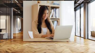 Young asian woman working at home. Female using computer laptop on desk at house Wall mural