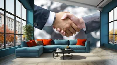 A close-up of two professionals shaking hands, symbolizing partnership and collaboration against a global backdrop. Wall mural