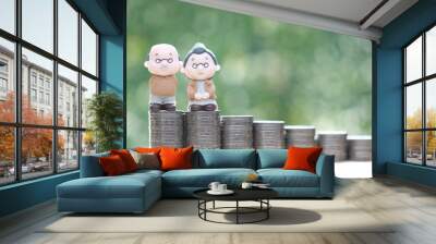 Mutual fund,Love couple senior and stack of coins money on natural green background, Save money for prepare in future and pension retirement concept Wall mural