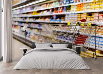 A shopping cart by a store shelf in a supermarket Wall mural