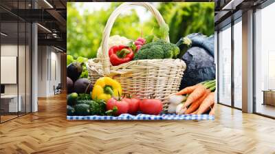 Assorted vegetables in wicker basket in the garden Wall mural