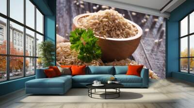 Composition with bowl of brown rice on wooden table Wall mural