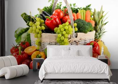 Organic vegetables and fruits in wicker basket isolated on white Wall mural