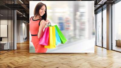 Young woman with bags in shopping mall Wall mural