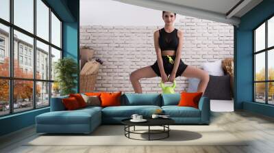 Woman exercise with pendulum weight in yoga style and image of fitness. Woman in sport clothing with muscular body. Concept of healthy lifestyle. Wall mural