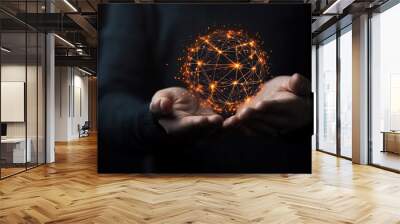 A person holds a glowing sphere representing technology and connection, illustrating innovation and digital transformation. Wall mural