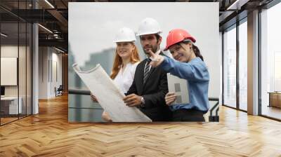 A portrait of an industrial man and woman engineer with tablet in a factory, working. Engineer Working on Computer, Project Manager, Another Specialist Joins Discussion. Team of Professionals. Wall mural