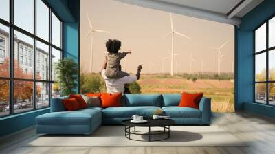 African american family in the community with wind generators turbines, Wind turbines are alternative electricity sources, the concept of sustainable resources and Renewable energy. sunset. Wall mural