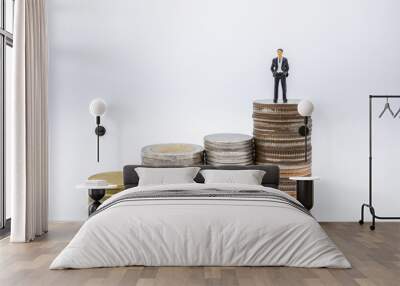 Business, Finance, Saving and secure concept. Close up of businessman minature figures standing on highest stack of coins on white background and copy space. Wall mural