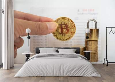 Money, Cryptocurrency Financial and Security Concept. Gold Bitcoin coin on man hand with stack of coin and master key lock on bank passbook. Wall mural