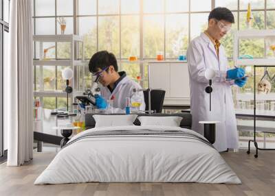 Portrait of two asian professional senior and young doctor scientist working and using microscope and research in working laboratory. Healthcare and science Concept. Wall mural