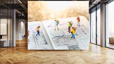 Travel Concept. Group of miniature with backpack walking and standing on passport with immigration stamps. Wall mural